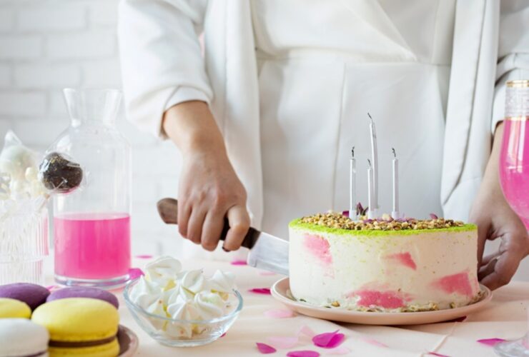 Mulher cortando bolo de aniversário com uma faca