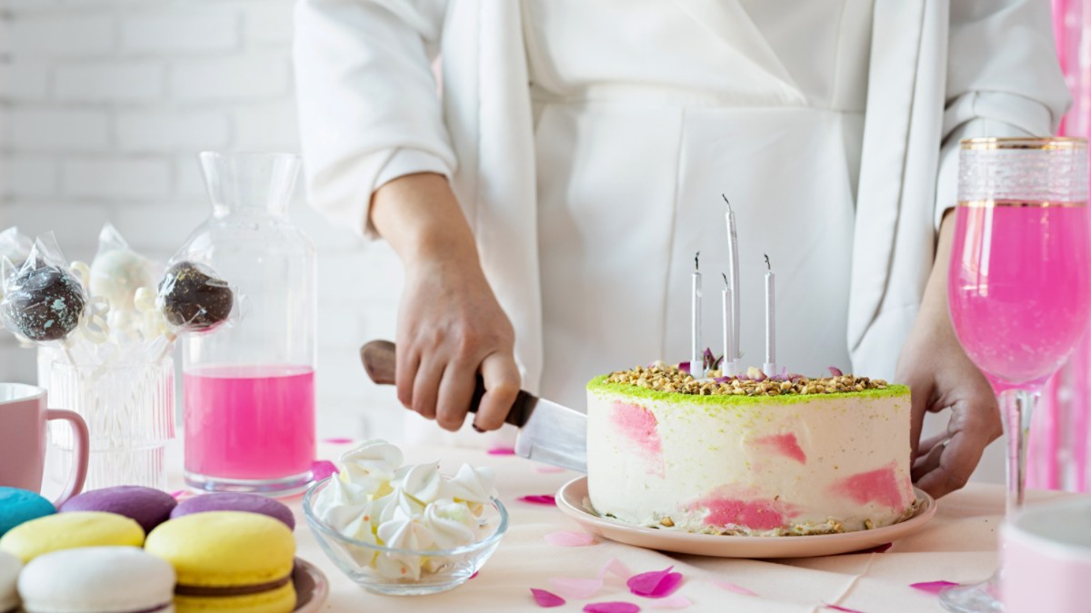 Mulher cortando bolo de aniversário com uma faca